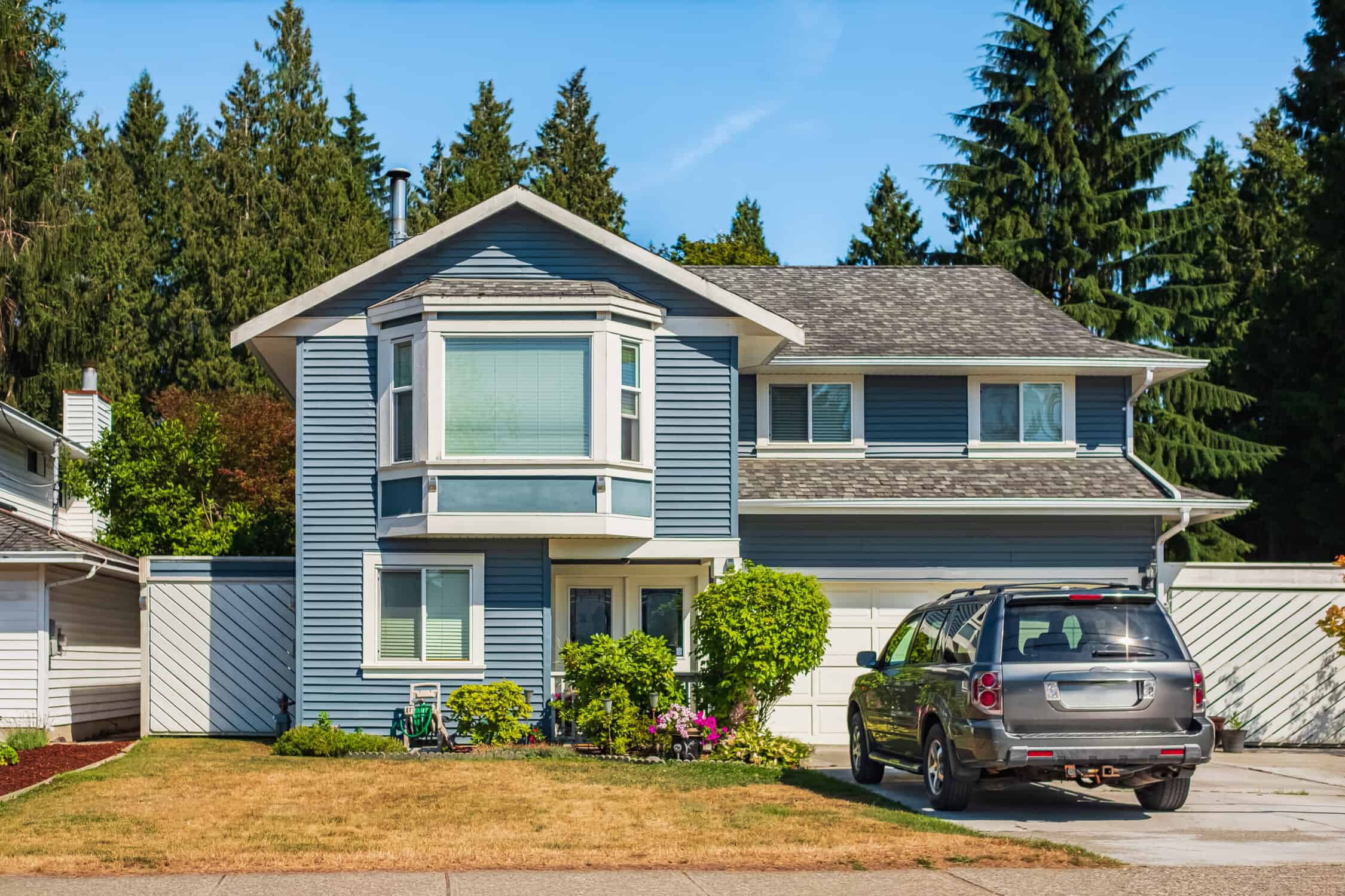 Big modern house with beautiful landscaping and driveway to garage. Front view of modern designed residential house.